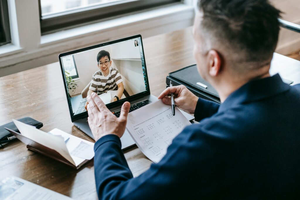 A professional having a video conference on a laptop from a home office, engaging in online communication.